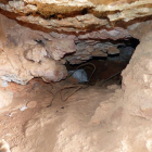 L’accés a la cova, amb restes de brossa que hi dificulten l’accés.