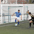 Un jugador del Lleida B controla la pilota sota l’atenta mirada d’un futbolista rival. 