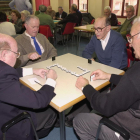 Un grupo de pensionistas juegan una partida de dominó.