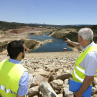Josep Maria Serra (d.), al costat del responsable de l’empresa, mostra la zona inundada de la presa, amb uns 400.000 metres cúbics d’aigua.