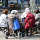 Un grupo de jubilados sentados en un banco de la ciudad de Lleida. 