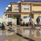 Vecinos de Los Alcázares retiran el lodo de sus casas.
