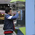 Un usuari en una cabina telefònica ubicada a rambla Ferran.