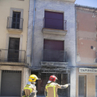 Imagen de la fachada del inmueble y, al fondo, la moto calcinada.