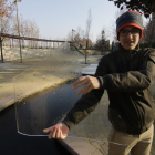 Un joven muestra una placa de hielo de uno de los pequeños estanques de los Camps Elisis de Lleida