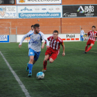 El local Edu Raya condueix la pilota davant l’oposició d’un jugador rival durant una ocasió del partit.