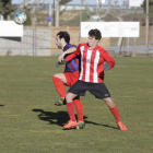 Un jugador local i un visitant lluiten per la pilota a Vilanova. 