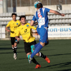 Dos jugadores del Lleida Esportiu B presionan a un jugador del Vilanova que cede el balón de cabeza.