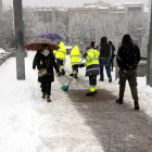 Operarios de limpieza barrían la nieve de la pasarela del Liceu Escolar de Lleida. 
