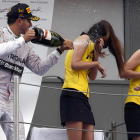 Hamilton mulla dos hostesses després de guanyar una cursa.