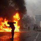 Un grupo de “chalecos amarillos” (gilets jaunes) se enfrentan con la policía antidisturbios cerca del Arco de Triunfo en París.