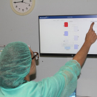 Un infermer col·loca una polsera de geolocalització a un pacient mentre una altra infermera inspecciona l’estat dels quiròfans que ja utilitzen aquesta tecnologia.