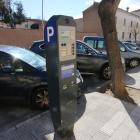 Un carrer amb places d’aparcament regulades per parquímetre.