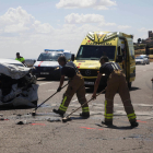 Dos bombers, treballant al lloc de l’accident al costat del cotxe en el qual viatjava la víctima mortal.