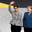 Annegret Kramp-Karrenbauer saluda a los militantes de la CDU acompañada de Merkel, ayer. 
