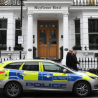 Un vehículo policial permanece estacionado a la entrada del hotel Mayflower de Londres.