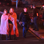 Dos mujeres envueltas en una sábana abandonan el área del tiroteo cerca del bar Borderline en la localidad de Thousand Oaks, California, Estados Unidos.