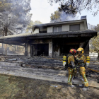 Dos bomberos hablan ante una de las viviendas afectadas por el incendio en la zona de la Marxuqera.