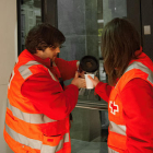 Dos voluntaris de Creu Roja Lleida serveixen cafè.