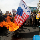 Iraníes queman banderas estadounidenses durante una manifestación contra la decisión de Trump.