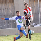 Un jugador del Bellcairenc golpea el balón pese a la presión rival.