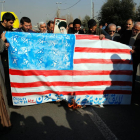 Un grup d’homes crema una bandera nord-americana durant una protesta a l’Iran.