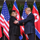 El president nord-americà, Donald Trump, i el líder nord-coreà, Kim Jong-un, inicien la cimera amb una encaixada.