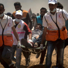 Efectivos sanitarios evacuan a un manifestante palestino herido durante las protestas en la frontera.