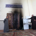 Varios palestinos observan los desperfectos en la mezquita.