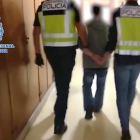 Imagen de dos agentes acompañando a César Román en su detención, ayer.