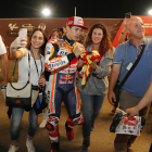 Marc Màrquez firma un autògraf a una aficionada, mentre altres es fan selfies amb el campió.