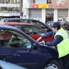 Una vigilant de zona blava imposa una multa a un vehicle.