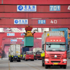 Varios camiones transportan contenedores en Qingdao.
