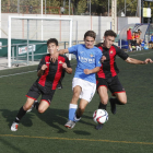 Un jugador del Lleida intenta avançar davant l’oposició de dos futbolistes del Reus.