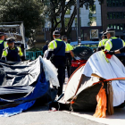 Agents de la Guàrdia Urbana retirant les tendes del campament de la plaça Catalunya, ahir.