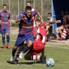 Un jugador del equipo local avanza con el balón ante la entrada de un rival.