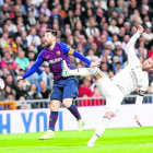 Messi intenta llevarse el balón ante Ramos que pretende frenarlo.