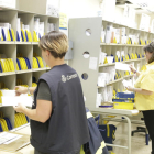 Dos treballadores classifiquen les cartes a les oficines de Correus al carrer Segòvia de Lleida.
