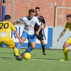 Un jugador del Mollerussa intenta escapar-se d’un rival amb la pilota controlada, ahir en el partit.