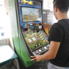 Un usuari jugant a una màquina escurabutxaques en un bar de Lleida.
