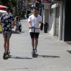 Dos usuarios  de patinetes eléctricos circulando por Lleida.