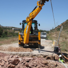 Els operaris treballen ara en el drenatge d’un dels camins, prop de la presa i del municipi (esquerra).