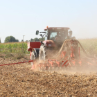 Imagen de un tractor en un campo de cereal en Gimenells.