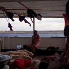 Alguns dels 147 migrants a la coberta del vaixell ‘Open Arms’ que ja es troben en aigües italianes, al davant l’illa de Lampedusa.