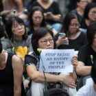Una hongkonesa sostiene una pancarta en la que se lee “Dejad de ser un enemigo del pueblo”.