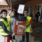 Alumnes transporten un punt de recollida a l’hora de l’esbarjo per fomentar el reciclatge correcte dels residus.