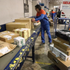 Un empleado de Seur reparte los distintos paquetes en las furgonetas para hacer los envíos, ayer. 