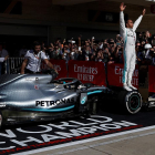 Lewis Hamilton celebra el seu sisè Mundial de Fórmula 1 damunt d’una roda del seu monoplaça.