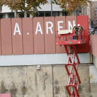 Operaris van tapar ahir les grans lletres del rètol d’“A. Areny” de la passarel·la dels Maristes.