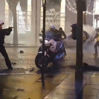 Un gendarme francés sacó su arma reglamentaria ante los manifestantes.